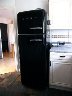 a black refrigerator freezer sitting inside of a kitchen