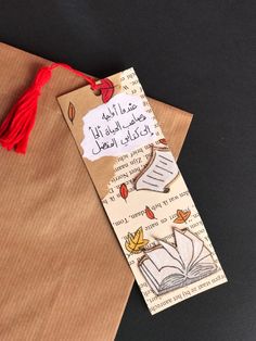 a bookmark with an open book on it and a tassel attached to it