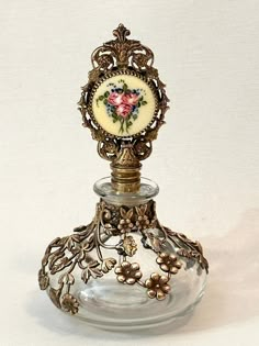 Antique Art Nouveau Floral Brass Overlay Perfume with Brass Filigree Guilloche Dauber - Brass  Cased Perfume - Vanity Decor - Collectible Perfume Bottles - Refillable Perfume - Gift for Her ~ MEASUREMENT: 3" across x  5-1/4" tall This is an exquisite Art Nouveau perfume bottle! It features a refillable glass perfume with open work casing of dainty brass flowers and leaves. The glass dauber has a beautiful brass filigree top with round enamel guilloche insert. This insert is a very pale yellow wi Antique Perfume Bottles 1920s, Vintage Decor Pieces, Vintage Perfume Bottles Aesthetic, Unique Perfume Bottles, Perfume Bottles Aesthetic, Cool Bottles, Perfume Bottle Tattoo, Antique Trinkets, Flower Perfume Bottle