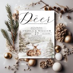 an image of a deer in the snow with pine cones and christmas decorations around it