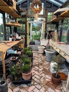 the inside of a greenhouse with potted plants and other things in pots on shelves