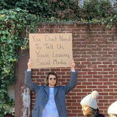 a woman holding up a sign that says you don't need to tell us you're leaving social media