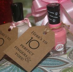 two nail polish bottles with tags on them sitting next to a pink bow and ribbon