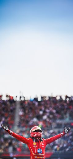 a man in a red suit standing on top of a race track