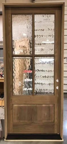 a wooden door with glass on the front and side panels, in a shop setting