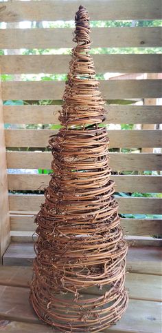 a wicker christmas tree sitting on top of a wooden table