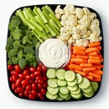 a platter filled with vegetables, dip and veggies on top of it