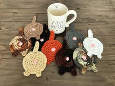 there are many crocheted animals next to a coffee cup