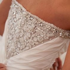 the back of a woman's wedding dress with beading