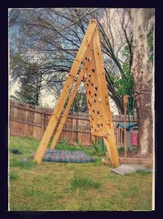 a wooden climbing wall in the backyard