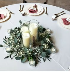 a table set with candles, flowers and napkins for an elegant dinner or party