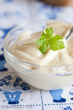 a glass bowl filled with yogurt on top of a blue and white table cloth