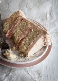 a piece of cake on a pink and white plate with a fork next to it