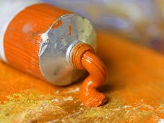 an orange and silver paint roller sitting on top of a wooden table