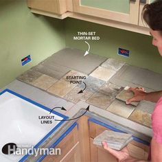 a woman is working on the tile in her kitchen