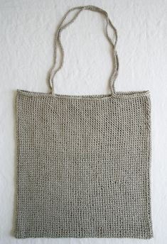 a knitted bag hanging on the wall next to a tweet hanger