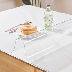 a plate with a donut on it next to a bottle of water