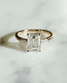 an emerald cut engagement ring with baguettes on the side