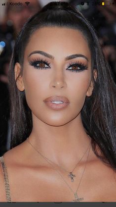 a woman with long dark hair and brown eyes is posing for a photo on the red carpet