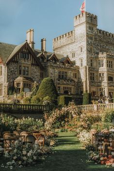 an old castle like building with lots of flowers around it