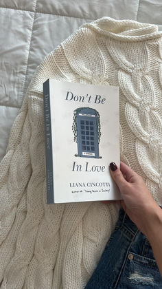 a person laying on top of a bed next to a book