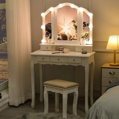 a white vanity with lights on it in a bedroom