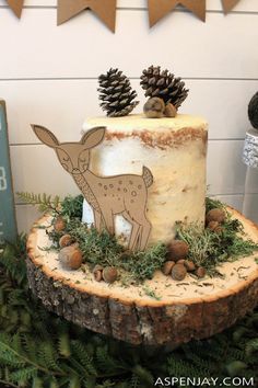 there is a cake that has been decorated with deer and pine cones on the top