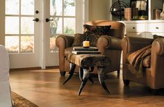 a living room with two chairs and a coffee table in front of a door that leads to the outside