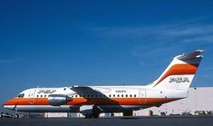 an orange and white airplane sitting on the tarmac