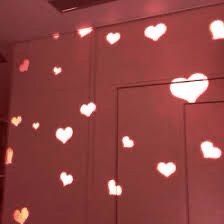 the light is shining on the wall and hearts are drawn on it with white paint