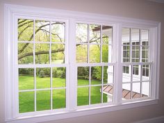 an open window with the view of a yard and tree in it's center