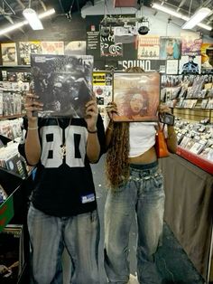 two people holding up records in front of their faces