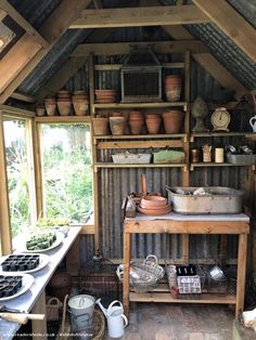 an old fashioned kitchen with pots and pans on the shelves in front of it