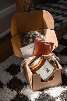 an open box with some food in it on a carpeted floor next to a chair