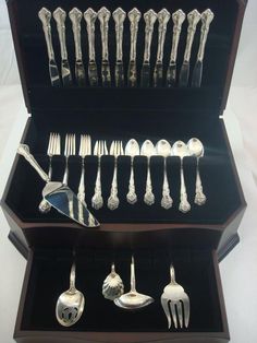 an assortment of silverware in a wooden box