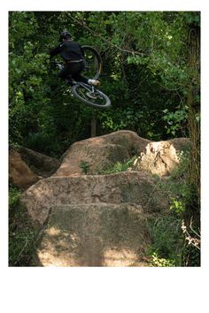 a person on a bike jumping over some rocks