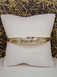 Circa 1990, a 14k yellow gold channel set baguette diamond hinged bangle bracelet. This bracelet features 62 tapered baguette diamonds totaling 0.95ctw (stamped carat weight and 14k inside). These diamonds are G/H color and VS clarity. Fit's 7.25" wrist. Condition is excellent. Weight is 18.6 grams. Thanks for looking. ERA - Circa 1990, Modern Vintage METAL / MATERIAL - 14k yellow gold MARKINGS - stamped carat weight and 14k inside CONDITION - The overall condition is very good! A true representation of 1990s-era jewelry! SIZE / MEASUREMENTS - Fit's 7.25" wrist. / Weight is 18.6 grams.  VINTAGE/ANTIQUE/HANDMADE - This item is VINTAGE. Add this timeless piece to your estate collection, to your wardrobe to jazz up any outfit, or gift it to an admirer of all things vintage and heirloom. Thank Diamond Bangle With Baguette Diamonds For Anniversary, Baguette Diamond Bangle For Anniversary, Anniversary Bangle With Baguette Diamonds, Anniversary Baguette Diamond Bangle Bracelet, Classic Bangle With Baguette Diamonds Cut, Yellow Gold Diamond Bracelet With Baguette Diamonds For Anniversary, Yellow Gold Baguette Cut Diamond Bracelet For Anniversary, Gold Baguette Cut Diamond Bracelet For Anniversary, Baguette Cut Yellow Gold Diamond Bracelet For Anniversary