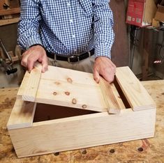 a man is working on some wood in his workshop with the help of two hands