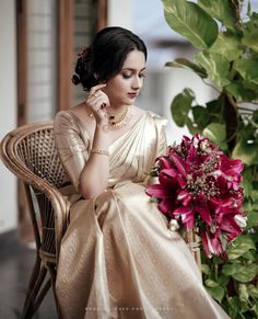 a woman sitting in a chair next to a flower