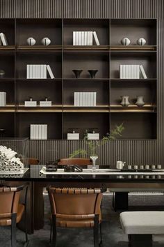 an elegant dining room with leather chairs and bookshelves