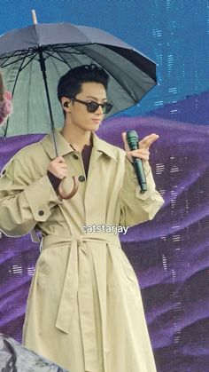 a man in a trench coat holding an umbrella