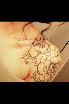 a woman with a rose tattoo on her shoulder is taking a selfie in the mirror