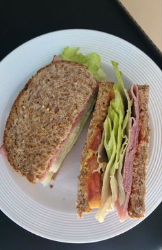 a white plate topped with a cut in half sandwich