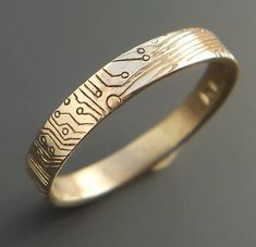 a gold ring with electronic circuit printed on the inside and inlayed to it