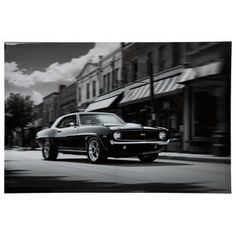 a black and white photo of a car driving down the street