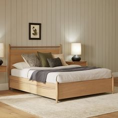 a large bed sitting in a bedroom on top of a wooden floor next to two nightstands