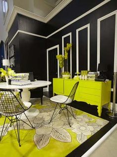 a black and white room with yellow accents on the walls, tables and chairs in front of them