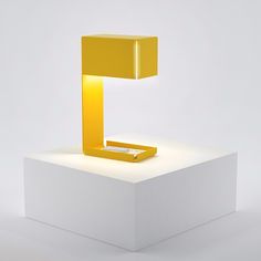 an illuminated yellow object sitting on top of a white platform