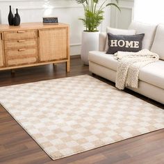 a living room with a white couch and brown rug