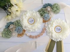 some flowers are sitting on a table with name tags attached to the flower petals and ribbons